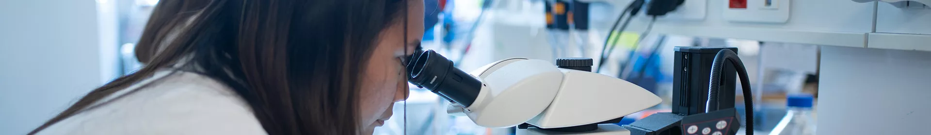Une chercheuse de l'Institut de la Vision regarde dans un miscroscope.